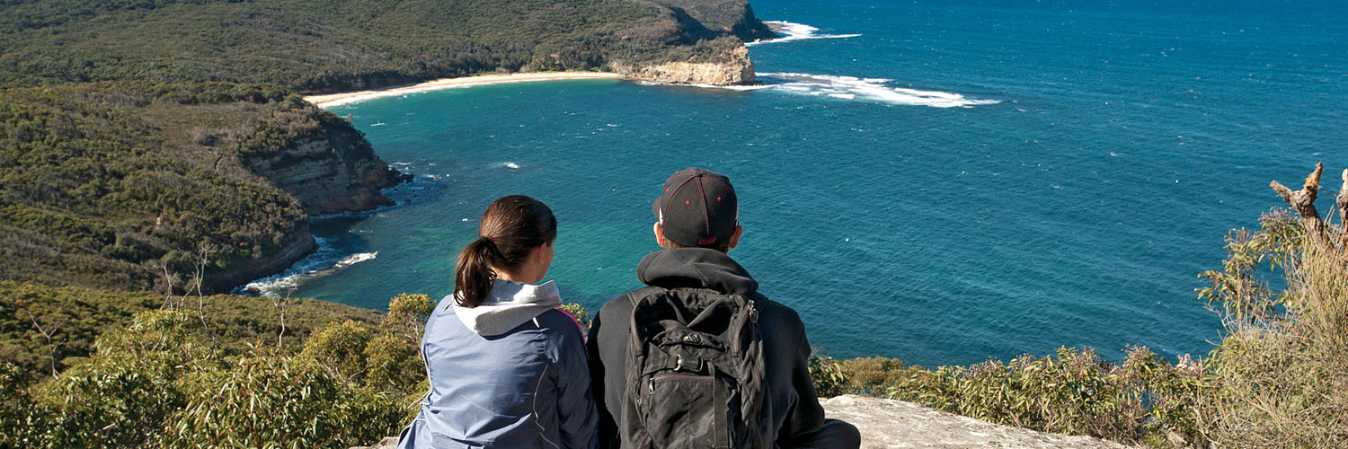 Hikers at Gerrin Point Lookout with view onto Maitland Bay in Bouddi National Park near Woy Woy, NSW. Credit: NSW Department of Planning and Environment / Don Fuchs