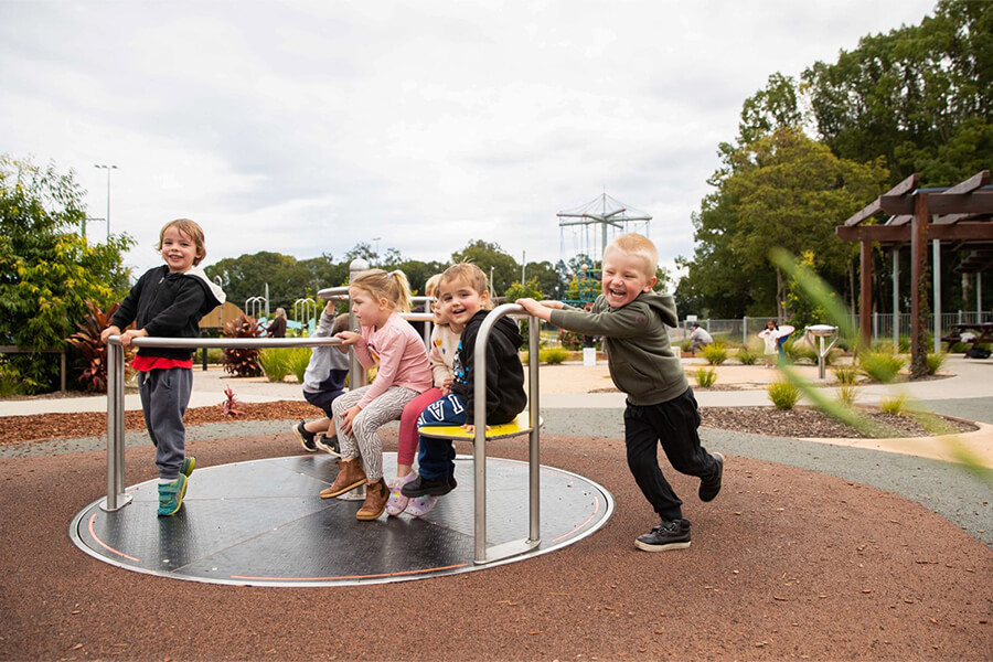 Children playing in a roundabout in the Bowraville Children's Playspace. Image credit: Nambucca Shire Council. 