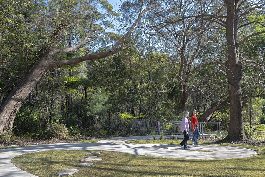 People walking in an open green area near the new accessible entry to Nandi Reserve.