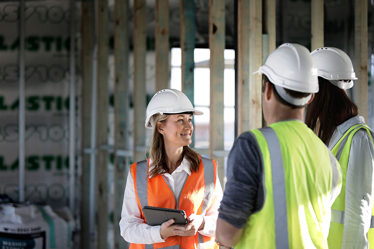 A female building certifier inspects scaffolding with her colleagues on a building site. Credit: NSW Department of Planning and Environment / Christopher Walters