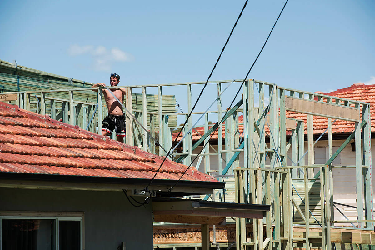 A builder works on a house under construction.