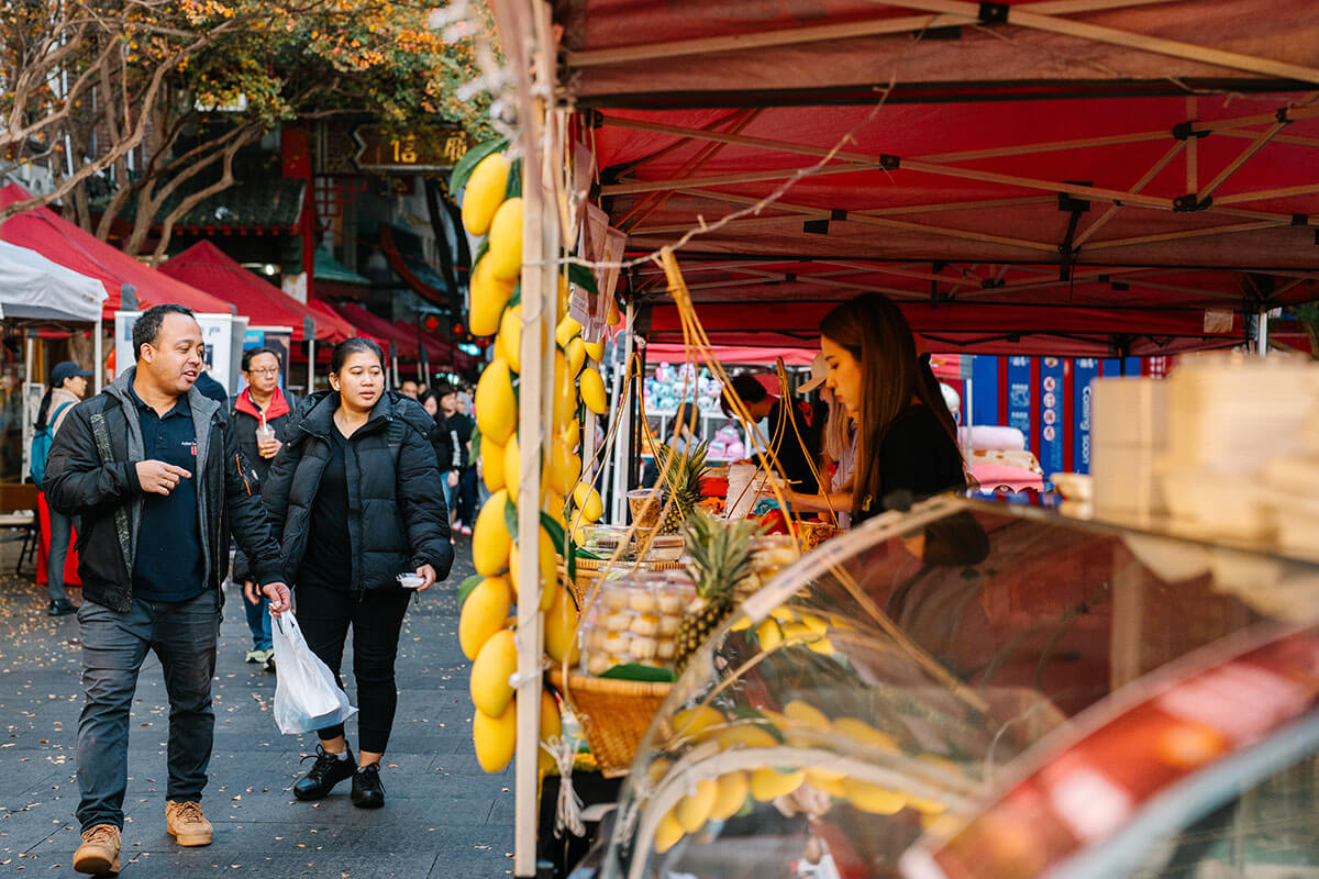 Couple walking past dessert market stall