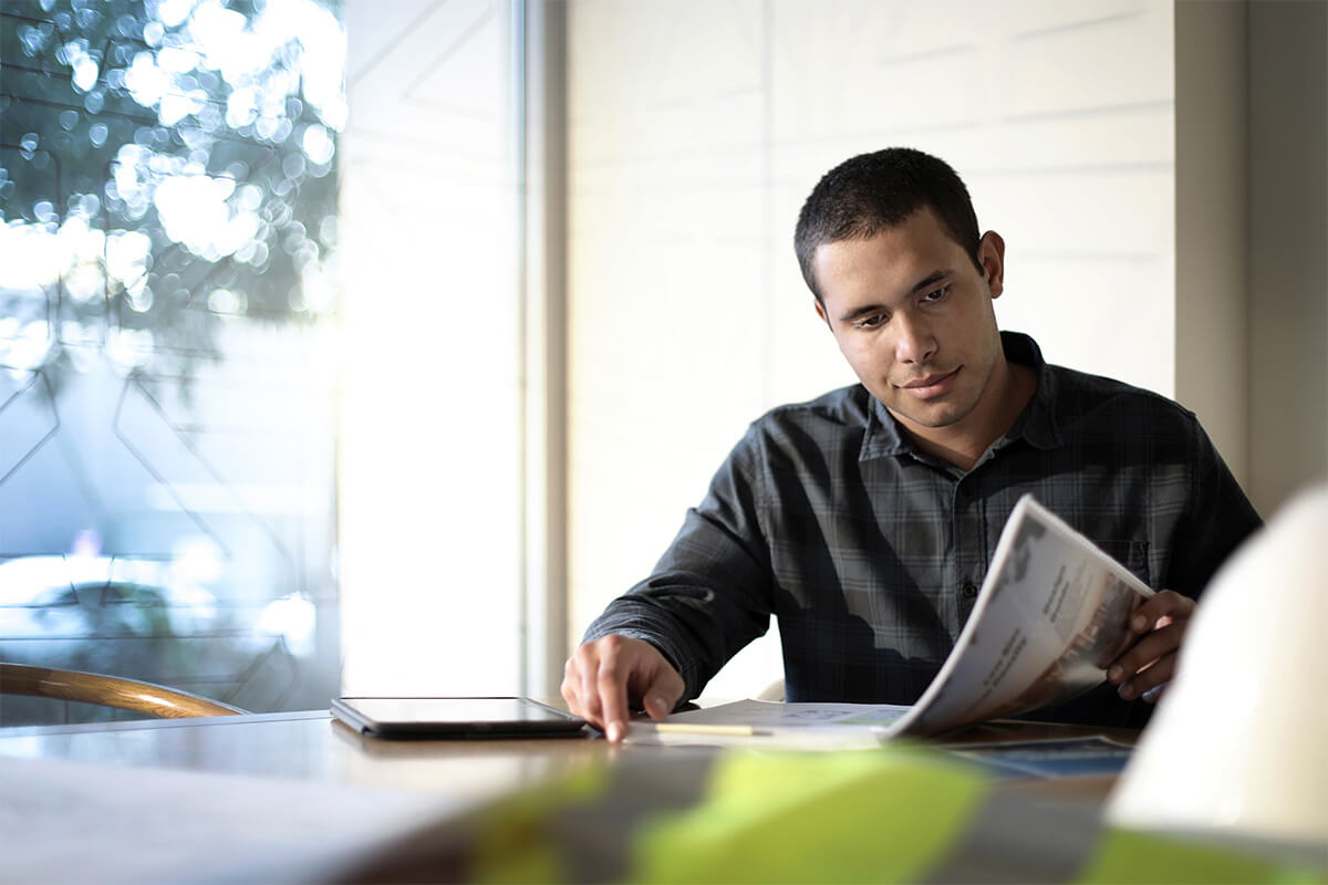 A male building certifier reads a housing guideline document. Credit: NSW Department of Planning and Environment / Christopher Walters