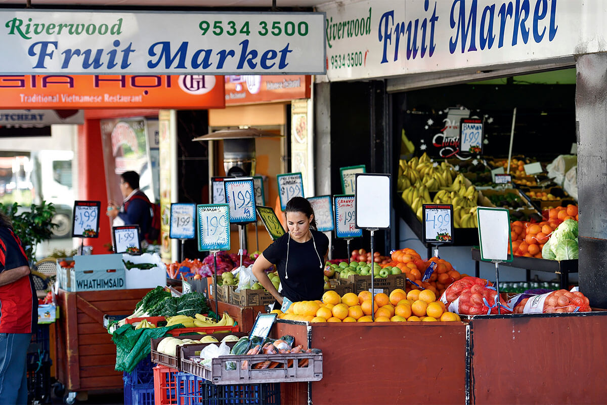 Person picking fruit on Belmore Road shops in Riverwood, South Sydney NSW. Credit: NSW Department of Planning and Environment / Adam Hollingworth