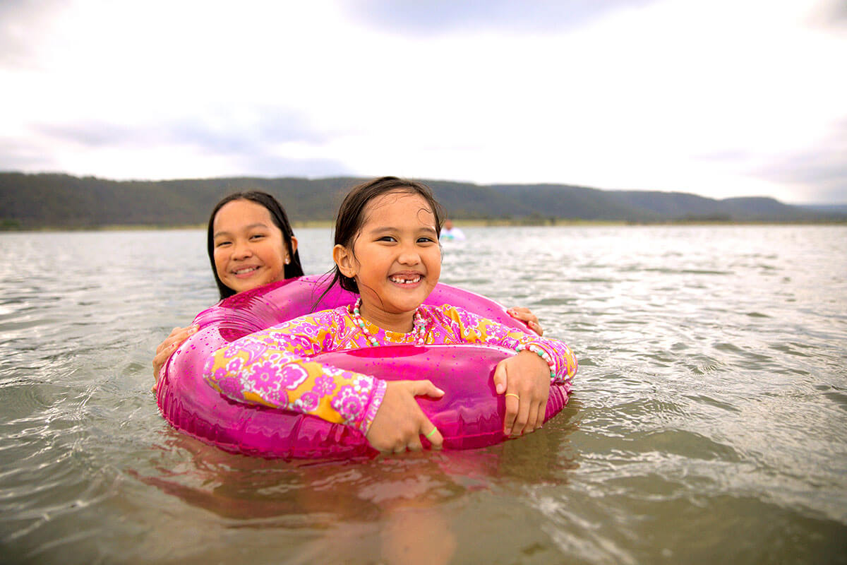 Two children swimming and having fun at Penrith Beach, NSW.